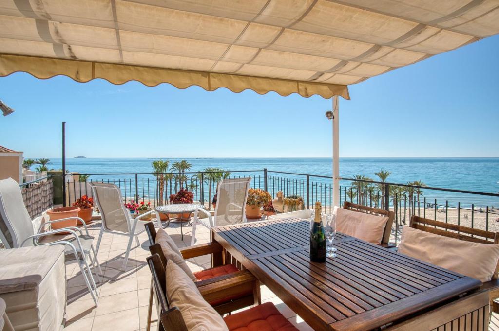 a patio with a table and chairs and the ocean at Casa amarilla del mar piso 3y4 in Villajoyosa