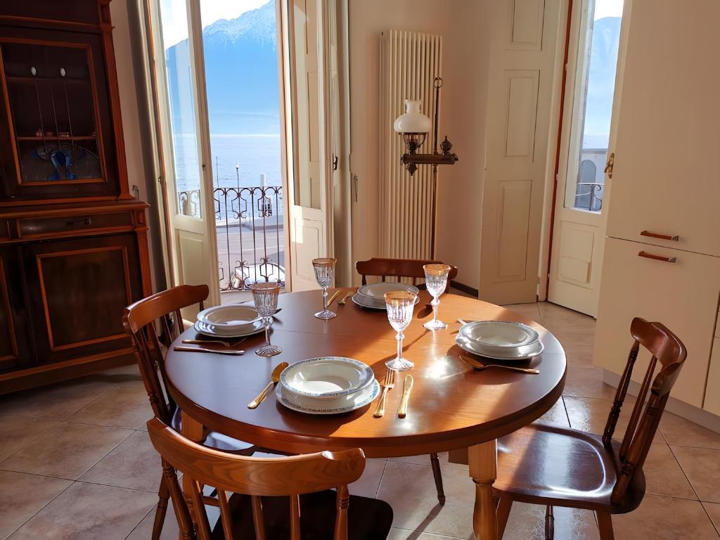 a dining room table with glasses and plates on it at Spacious Historic Apartment F1 in Gravedona