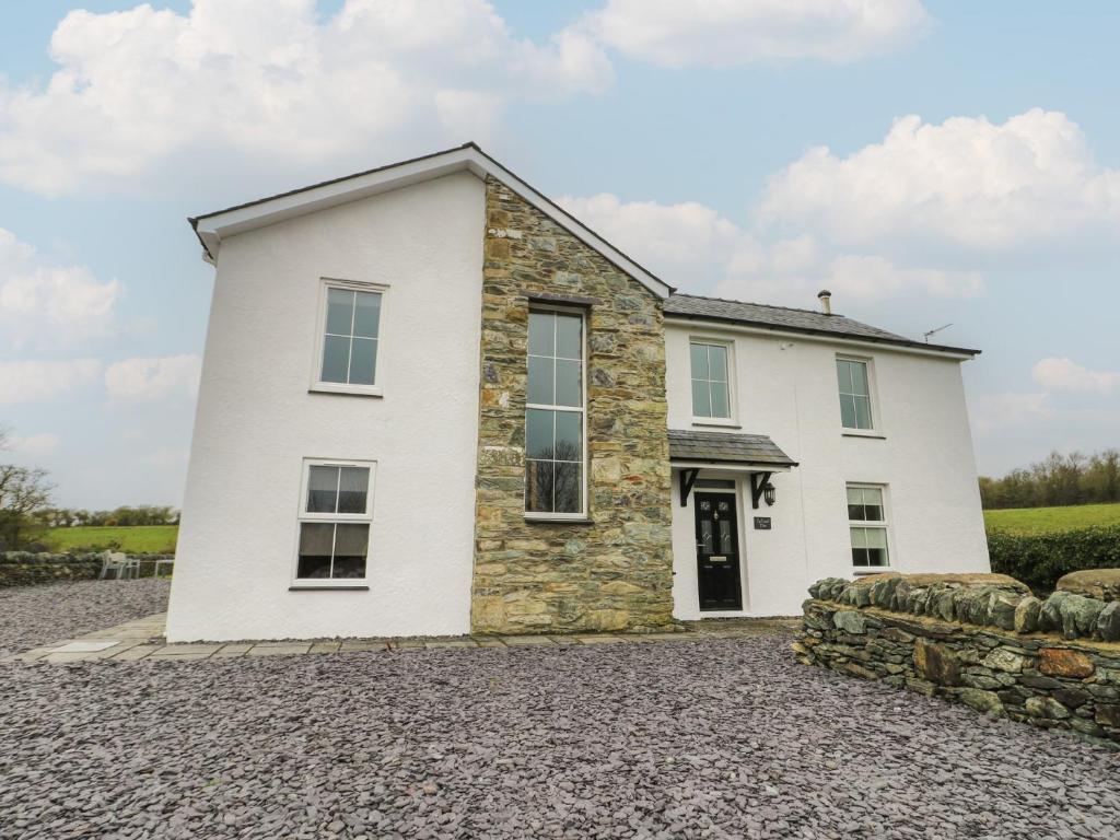 a white house with a stone driveway at Chapel House in Llantrisant