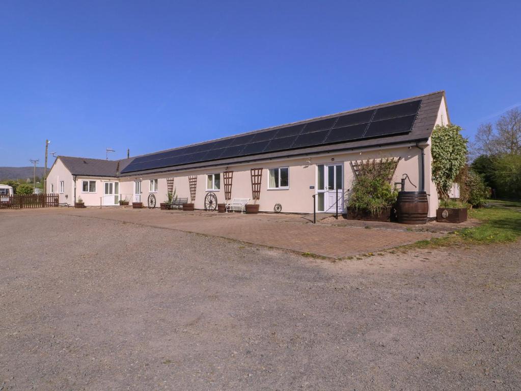 a large white building with a solar roof at The Turbles - Wagtail in Castlemorton