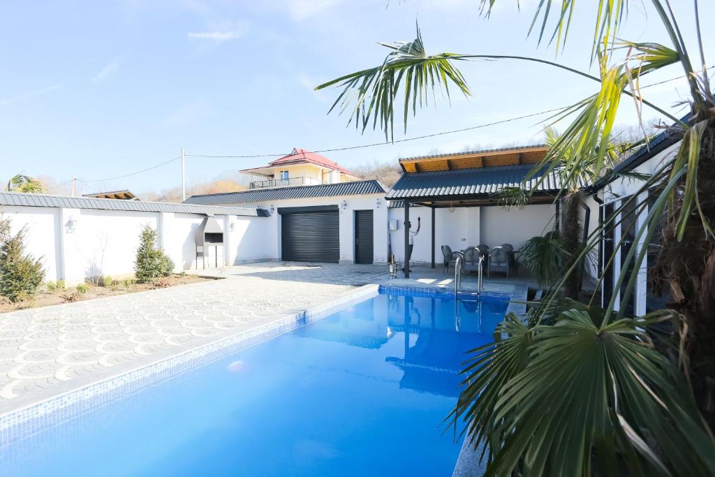 a villa with a swimming pool and a house at Forest Luxe A-Frame Villa in Quba