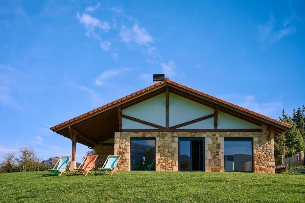 a group of chairs in front of a house at Basque Haven by Fidalsa in Zeanuri