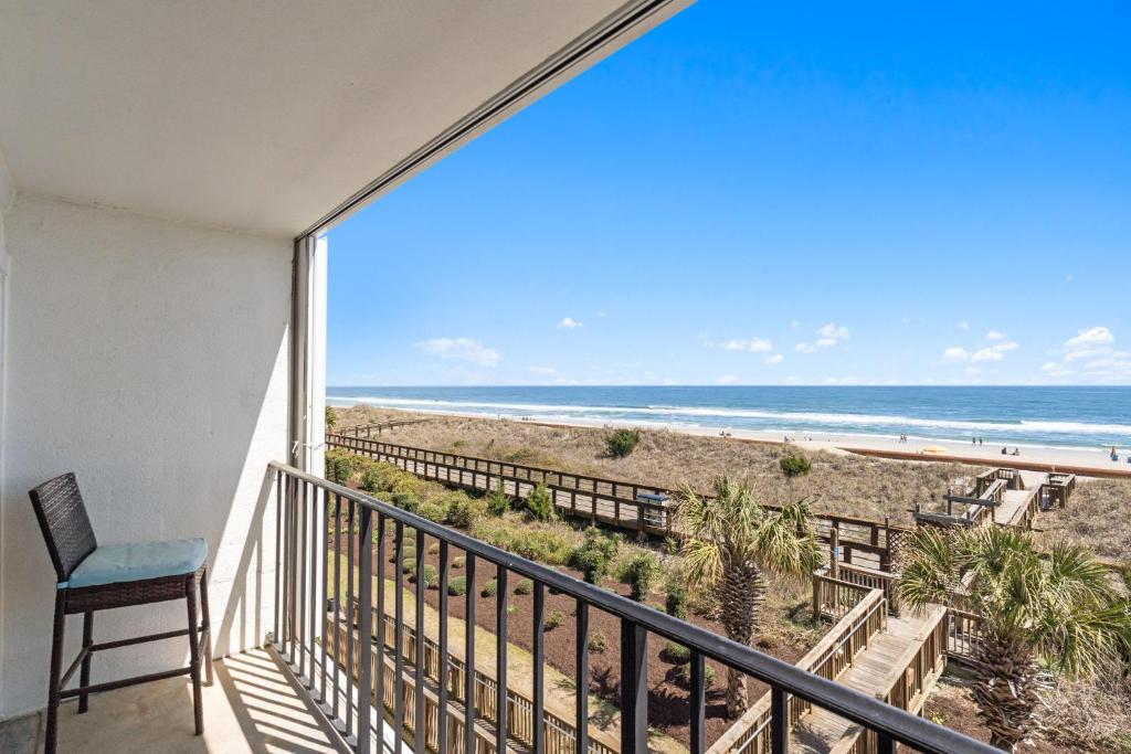 a balcony with a view of the beach at CB Boardwalk Condo Oceanfront Pool Villa in Carolina Beach