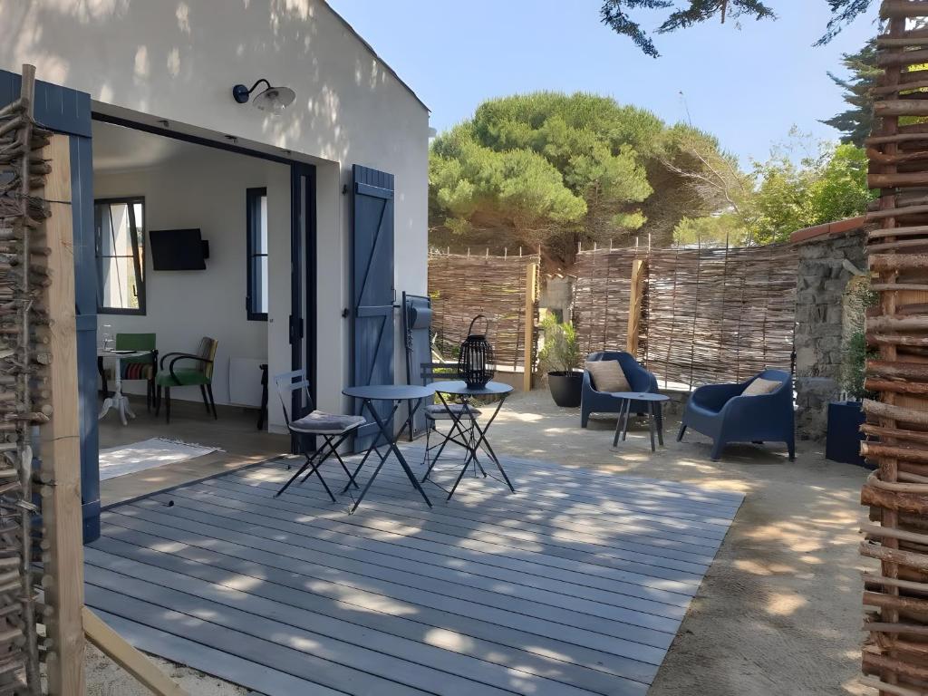 a patio with chairs and a table on a deck at Chambres D'hôtes - Noirmoutier in LʼÉpine
