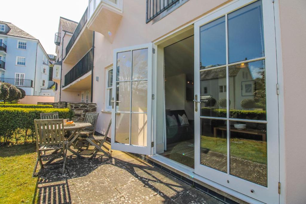 a patio with a sliding glass door and a table at 3 Combehaven in Salcombe