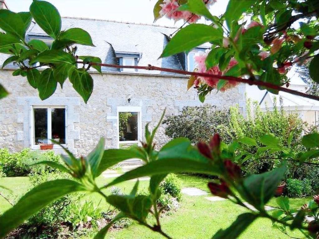 a stone house with a garden and flowers in front of it at Gites Air Marin in Lannion