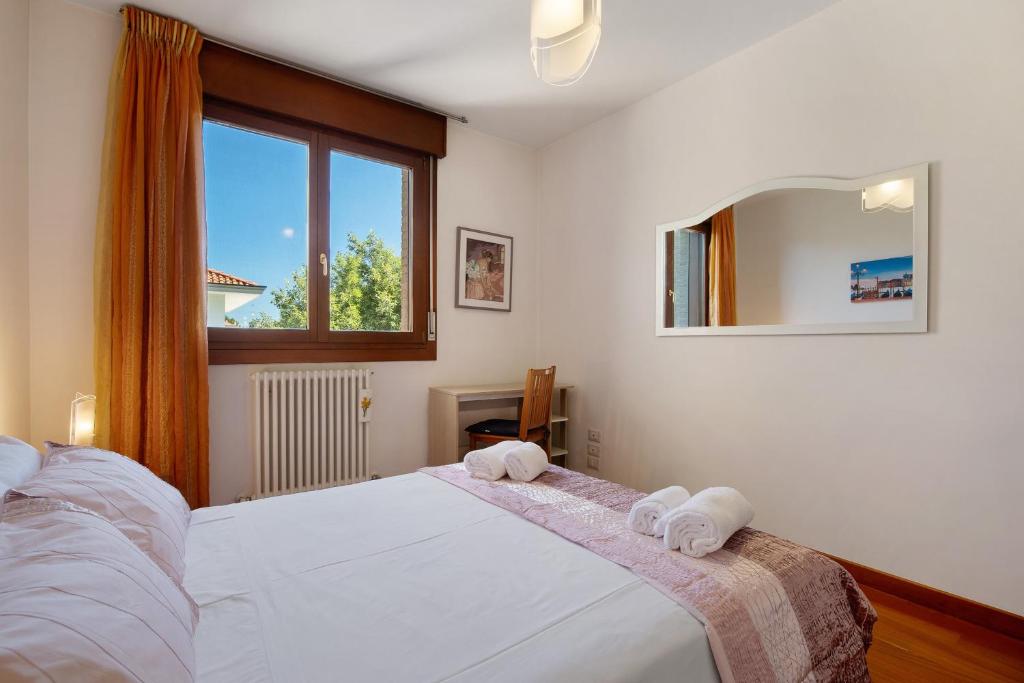 a bedroom with a white bed with towels on it at Casa Andrea in Venice