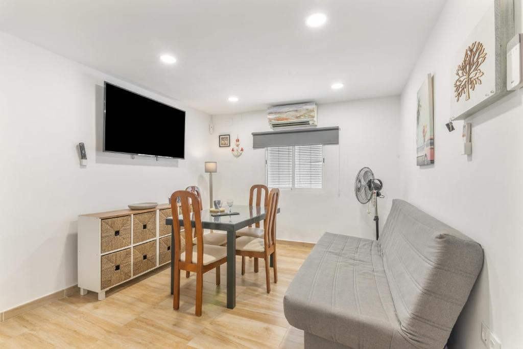 a living room with a table and chairs and a tv at Encanto Costero in Ayamonte
