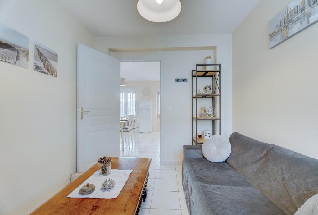 a living room with a couch and a table at Grain de sable in Saint-Benoît-des-Ondes