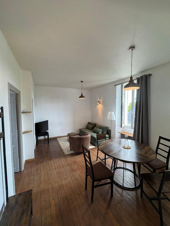 a living room with a table and a couch at Cocon urbain avec jardin - appartement proche hôpital in Angers