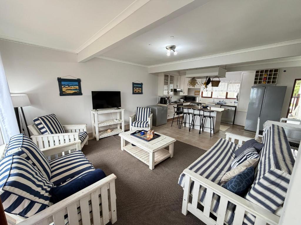 a living room with blue and white striped couches at LaMer No 5 in Stilbaai
