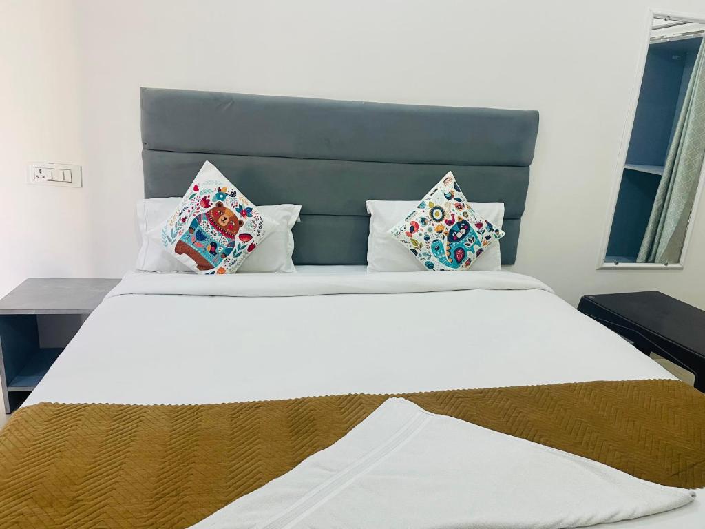 a bedroom with a large white bed with pillows at Hotel The regal inn in Varanasi