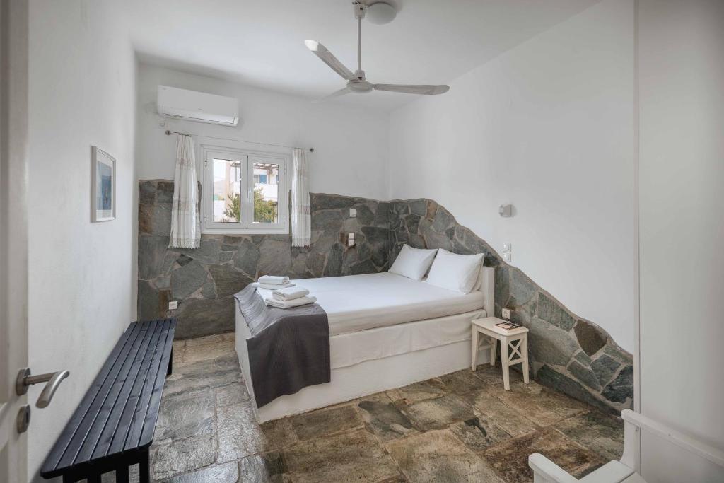 a bedroom with a bed with a stone wall at House Avlomonas in Livadi