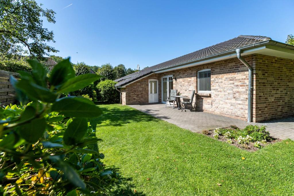 a brick house with a patio and grass at Ferienhaus Christine in Breklum
