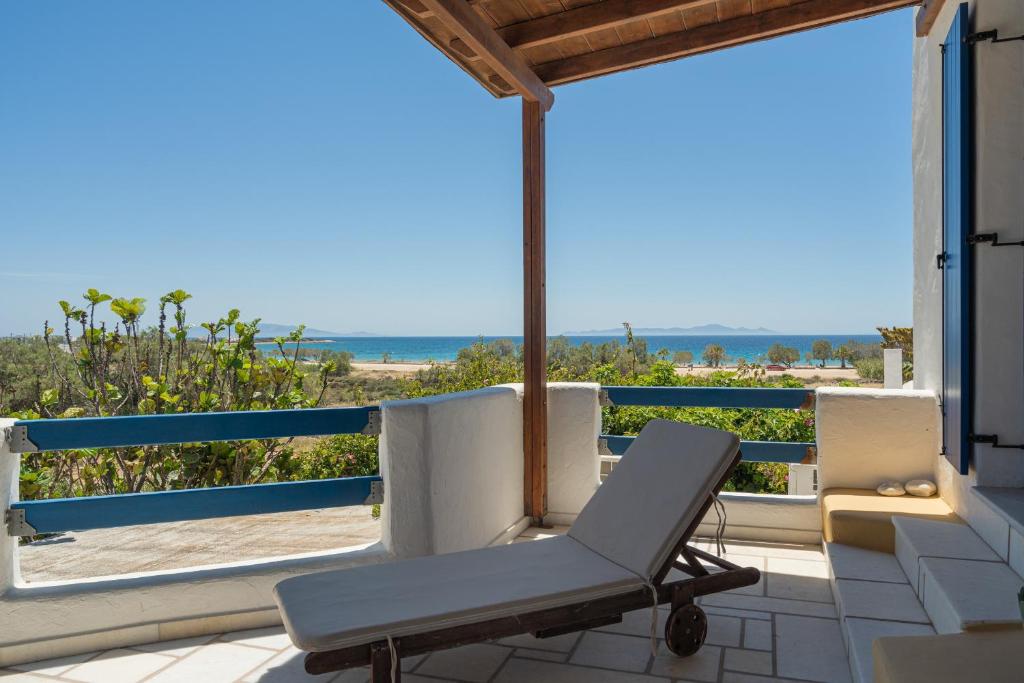 a chair on a balcony with a view of the ocean at Maria's Village Suite in Kampos Paros