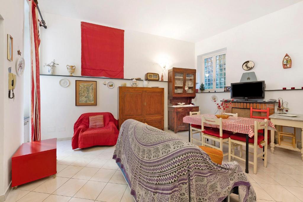 ein Wohnzimmer mit einem roten Sessel und einem Tisch in der Unterkunft Giomar in Levanto
