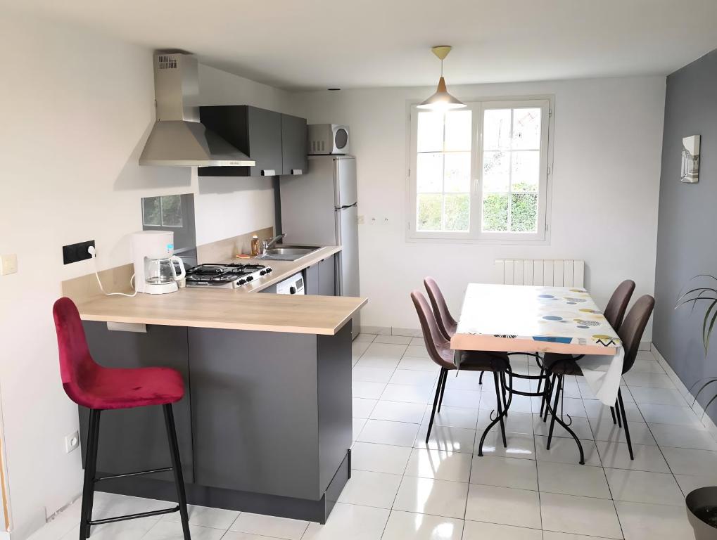 a kitchen with a table and chairs and a dining room at Grand Gîte Avec 2 Chambres in Saint-Pol-sur-Ternoise