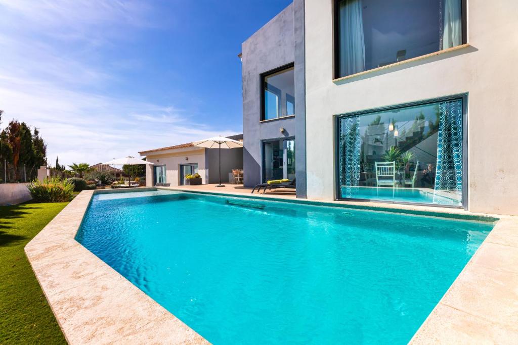 a swimming pool in front of a house at Villa La Primera in Llucmajor