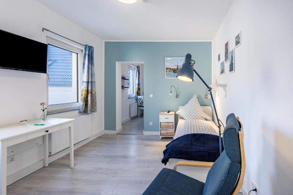 a bedroom with blue walls and a desk and a bed at Friesenstube in Kerken