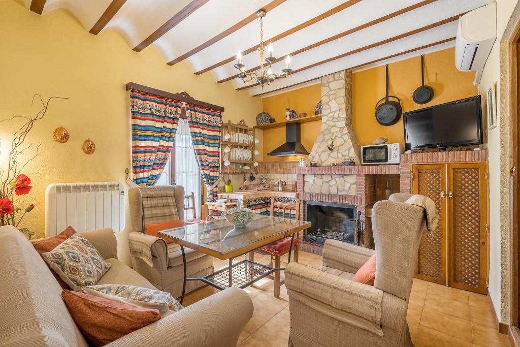 a living room with a table and a fireplace at Lavanda in Hinojares