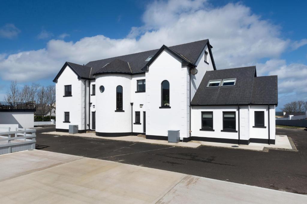 a white church with a black roof at Ocean Breeze Apt 3 in Dunfanaghy