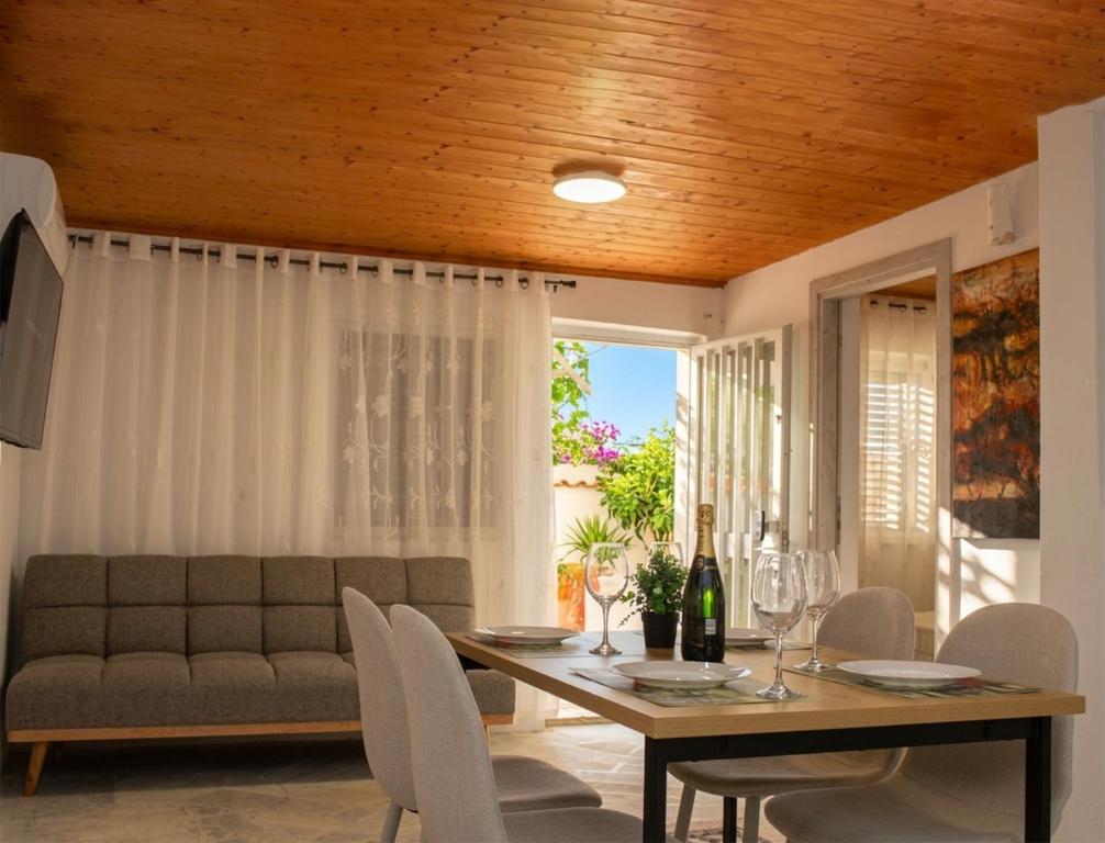 a dining room with a table and chairs and a couch at The Beach White House - 80m from the Beach - Renovated in Áyios Yeóryios