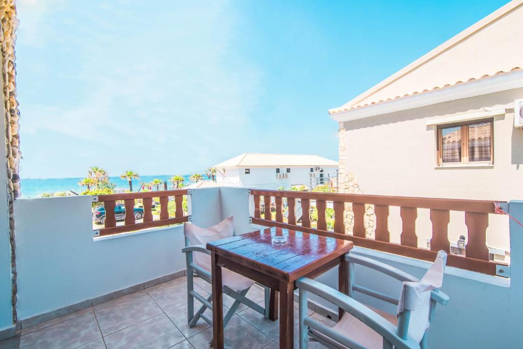 a balcony with a table and chairs and the ocean at Mirage Arillas Studio Type A1 in Arillas