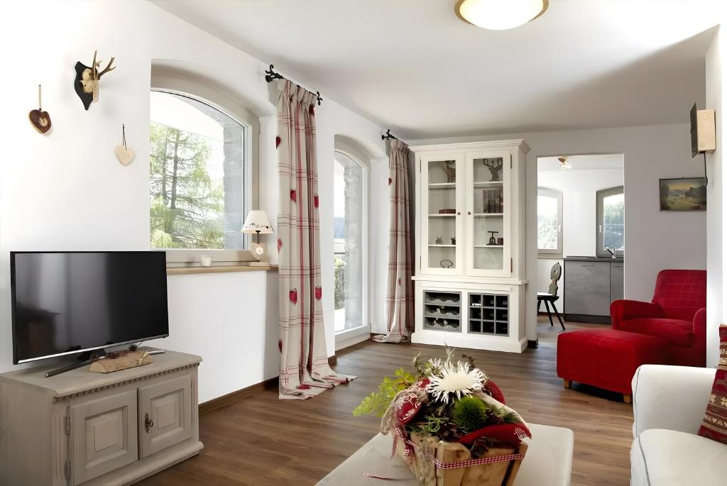 a living room with a tv and a red couch at Hotzenwald in Ibach