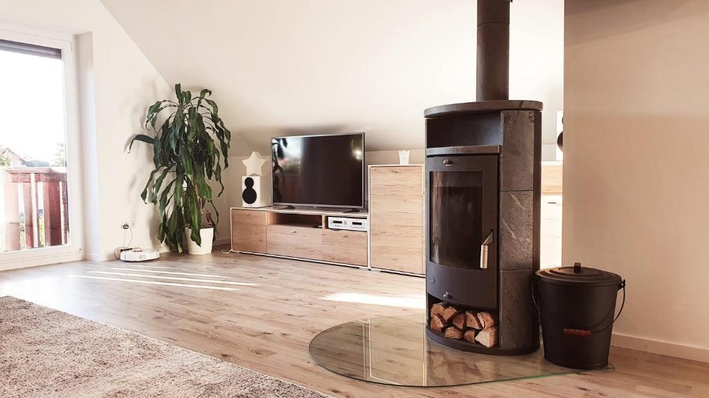 a fireplace in a living room with a tv at Ferienglück Goldach in Hallbergmoos