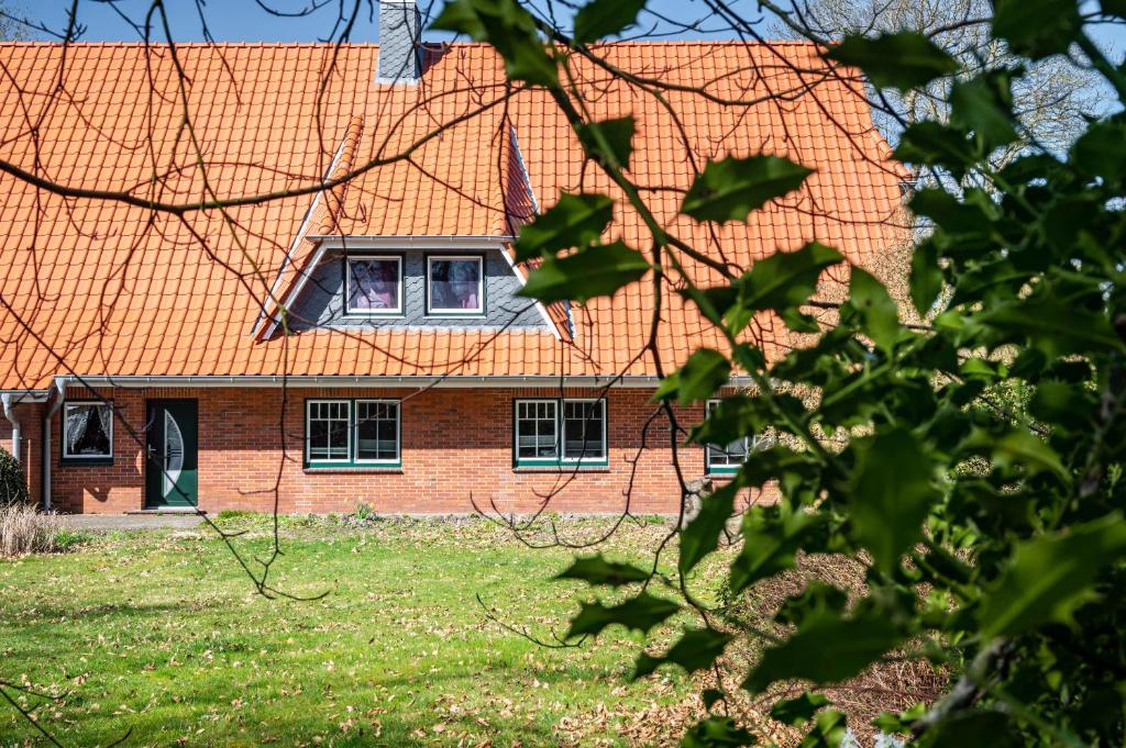 a brick house with an orange roof at Fewo Heimathafen in Osterbruch