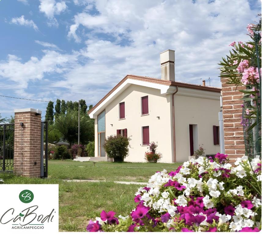a white house with flowers in front of it at Agricamping Ca' Bodi Veneto in Cavallino-Treporti