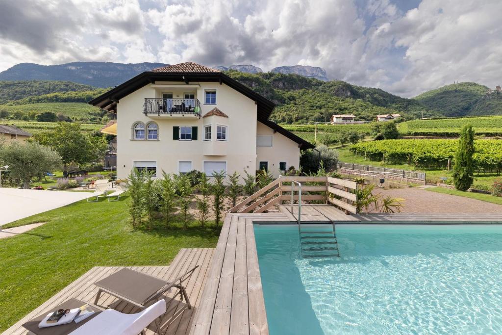a villa with a swimming pool and a house at Apartment Weingut Zail in Appiano sulla Strada del Vino