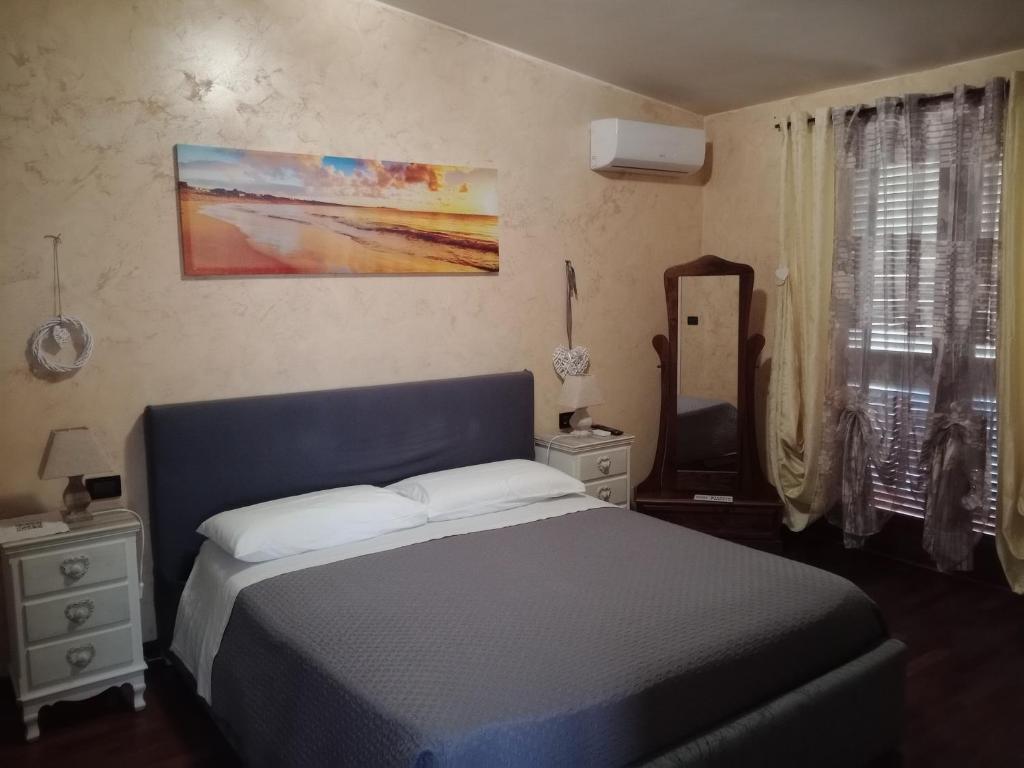 a bedroom with a blue bed and a mirror at I 4 mori in Fiumicino