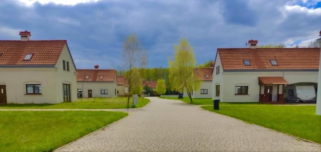 a walkway between two houses in a yard at Mazurska Oaza in Pisz