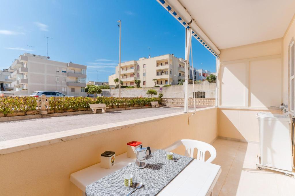 a table and chairs on a balcony with a view of a city at Alice's house in Otranto