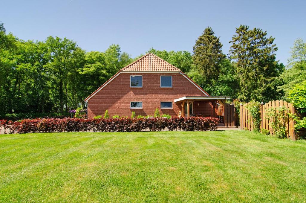 a house with a yard and a fence at Ferienwohnung Otte in Apen