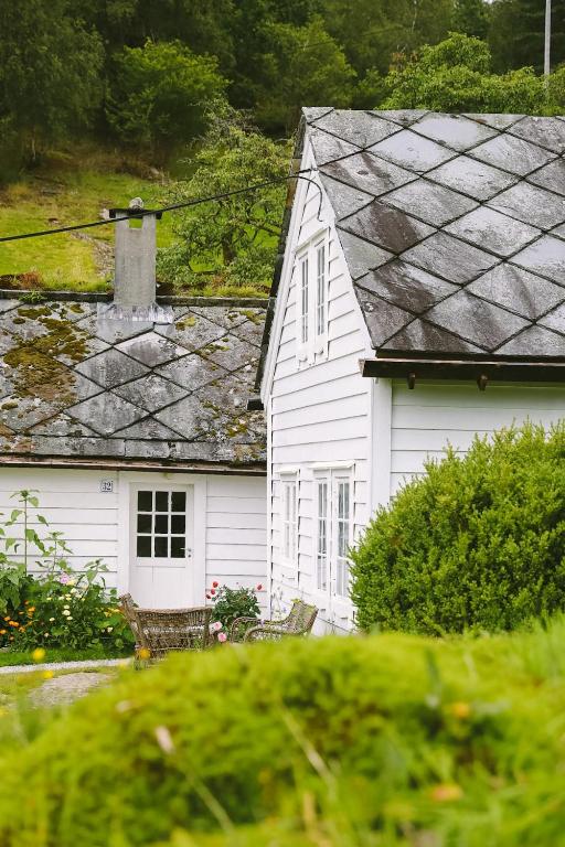 a white house with a gray roof at Aarvik organic farm & bakery in Tveit