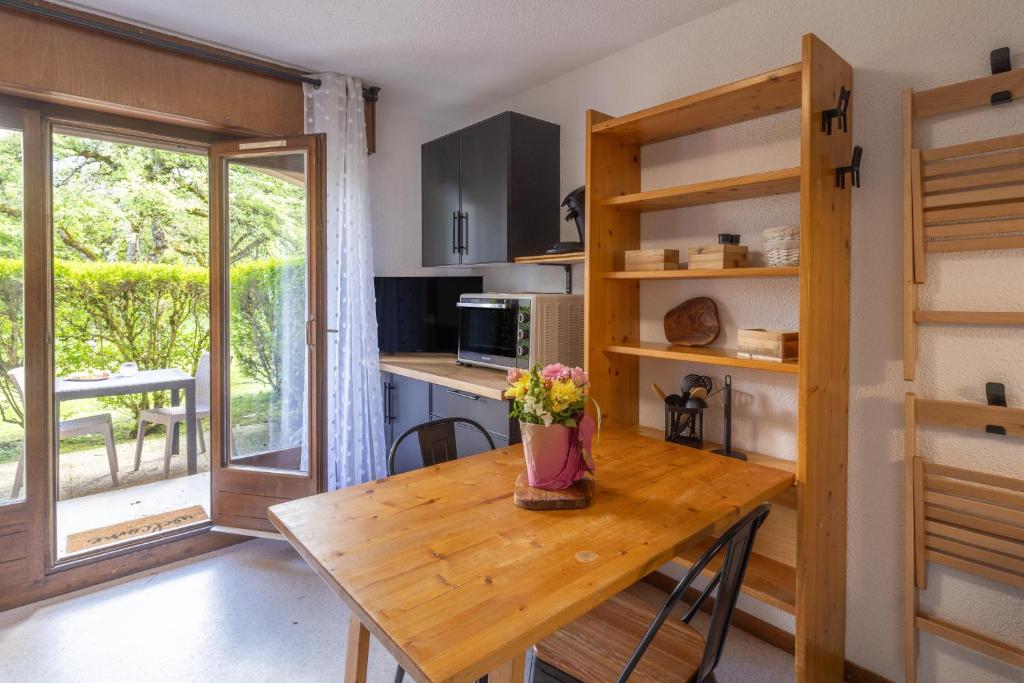 a kitchen with a wooden table with flowers on it at Les chalets du Praz 4 - Immoclean in Morillon