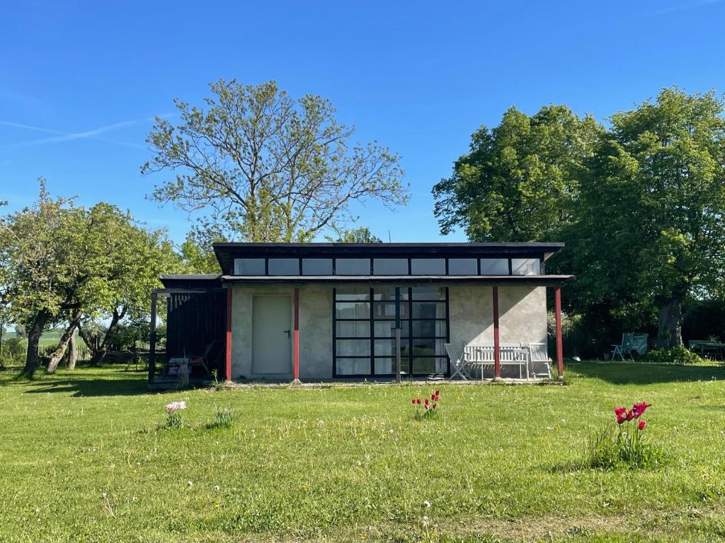 a small house in a grassy field with trees at Ferienwohnung Teehaus in Saal