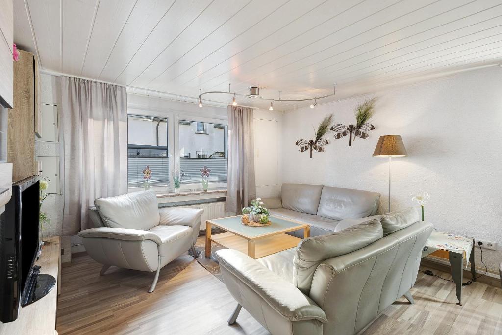 a living room with a couch and two chairs at Pension Neuenrade in Neuenrade