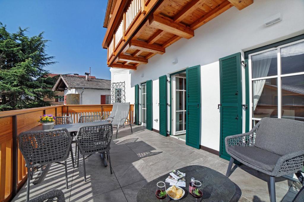 a patio with chairs and a table on a balcony at Engel Appartements Goschtstub in Parcines