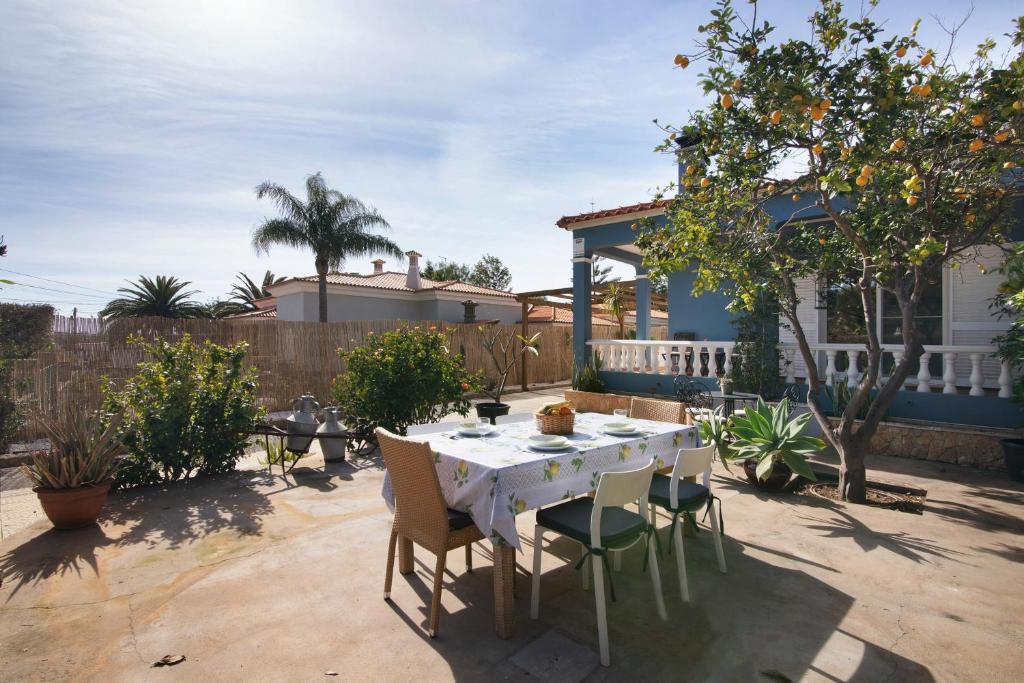 a patio with a table and chairs in a yard at Casa das Buganvilias in Loulé