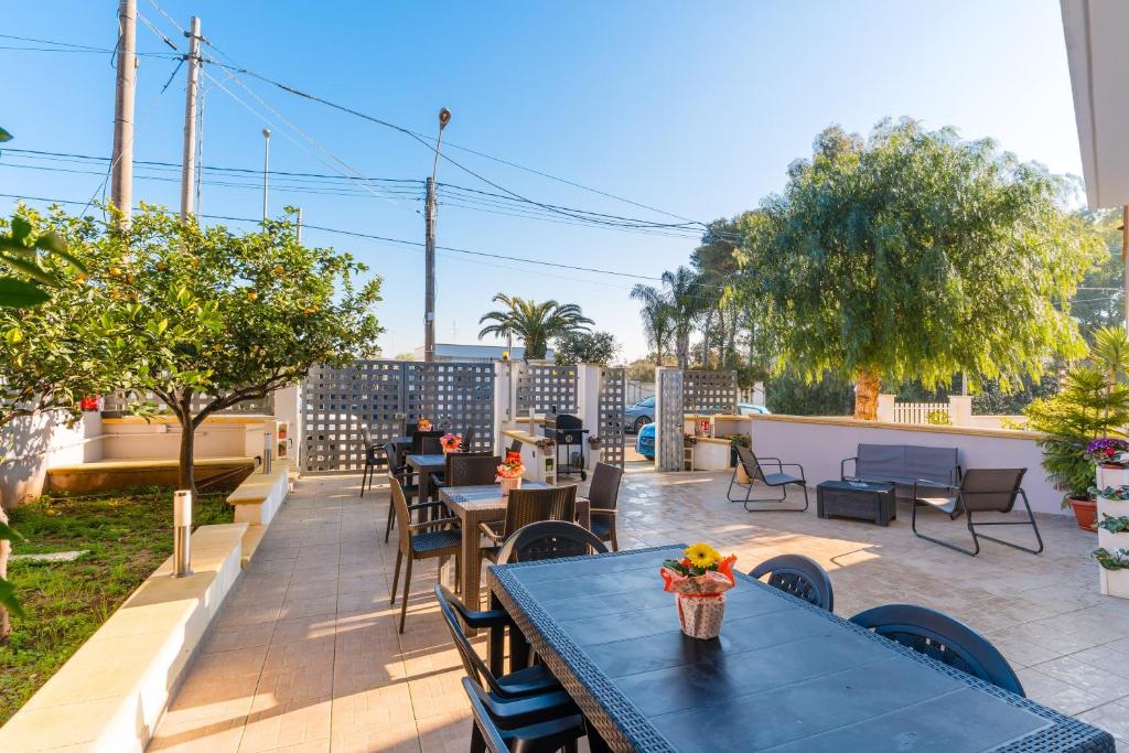 a patio with tables and chairs and trees at Luxury 12 in Tuglie