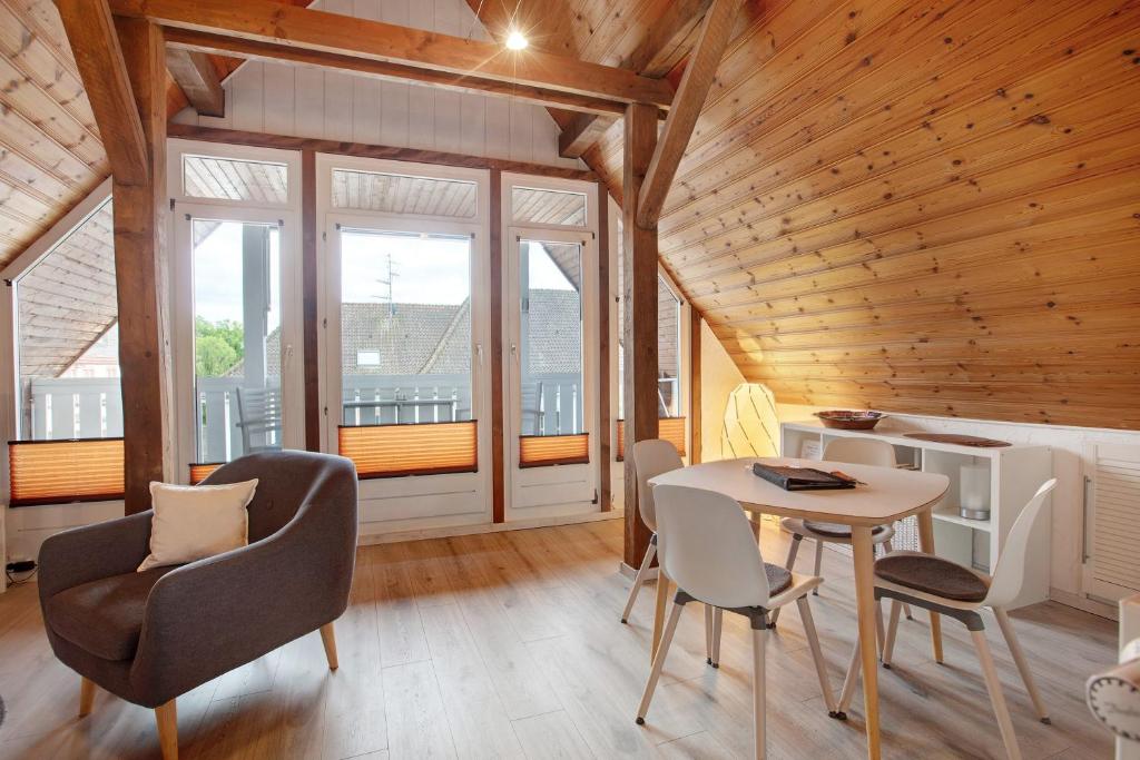a living room with a table and chairs and windows at Ferienwohnung Dashaus in Rheinfelden