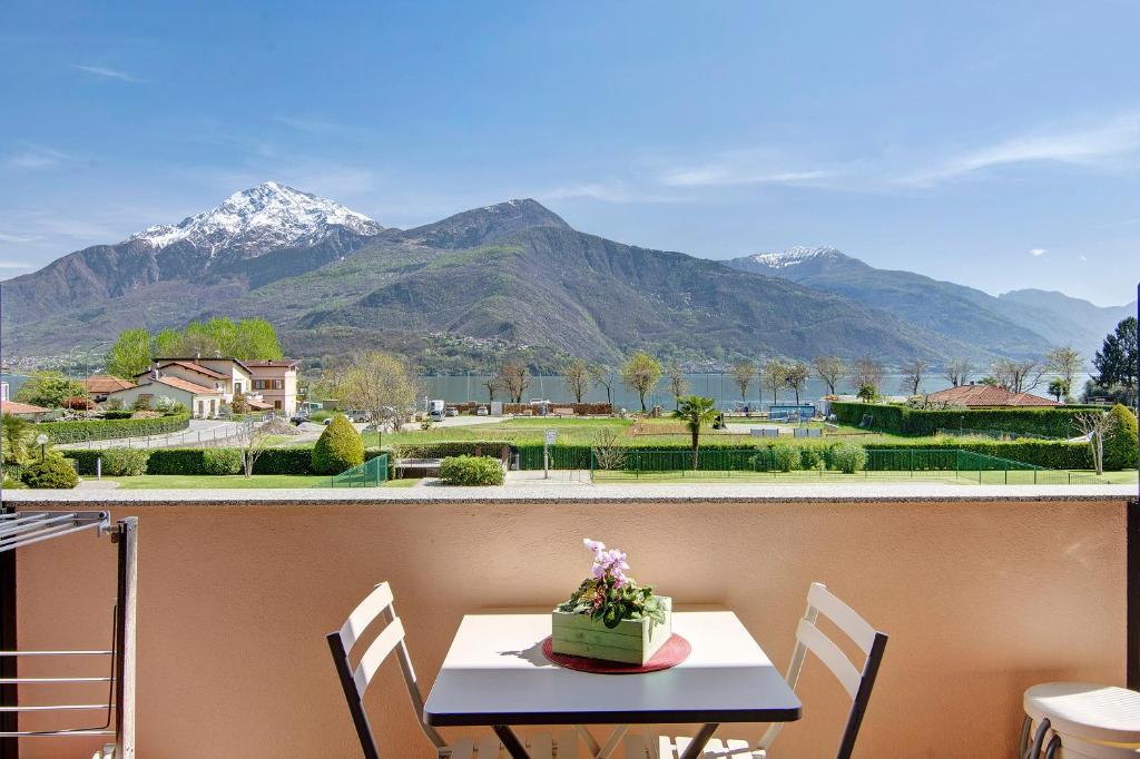 a table and chairs with a view of mountains at Casa vacanze vigna del Lago in Dongo