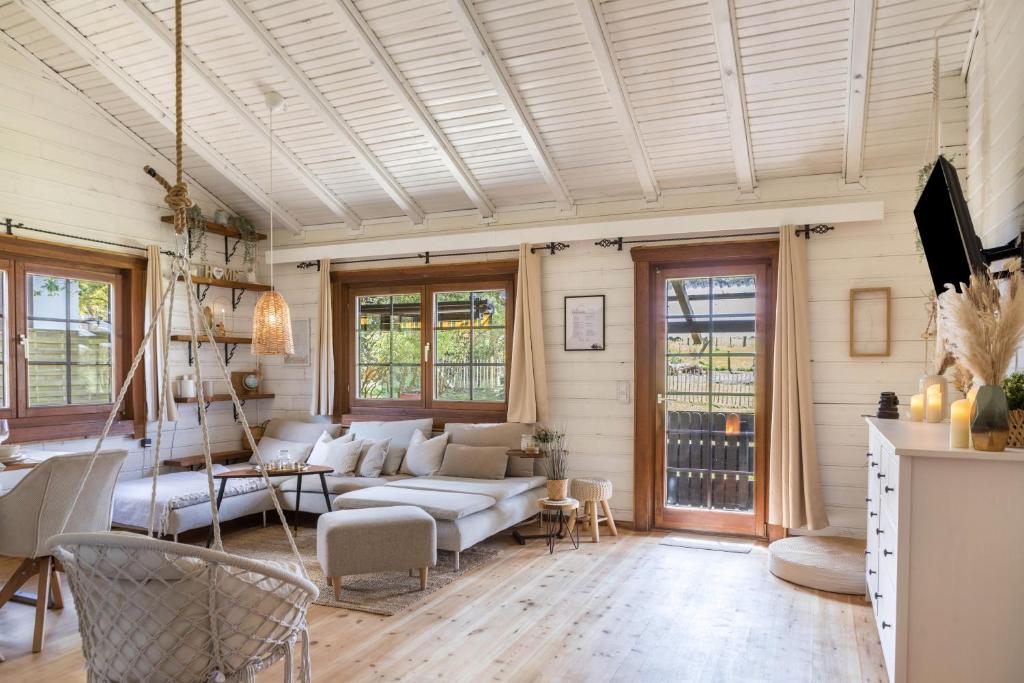 a living room with a white couch and chairs at Almhütte in Ulrichstein