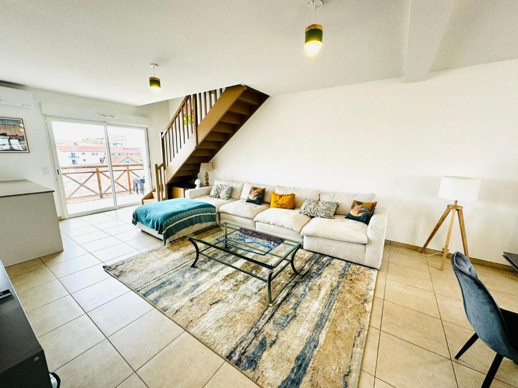 a living room with a couch and a table at Superbe duplex au pied de la plage in Mimizan