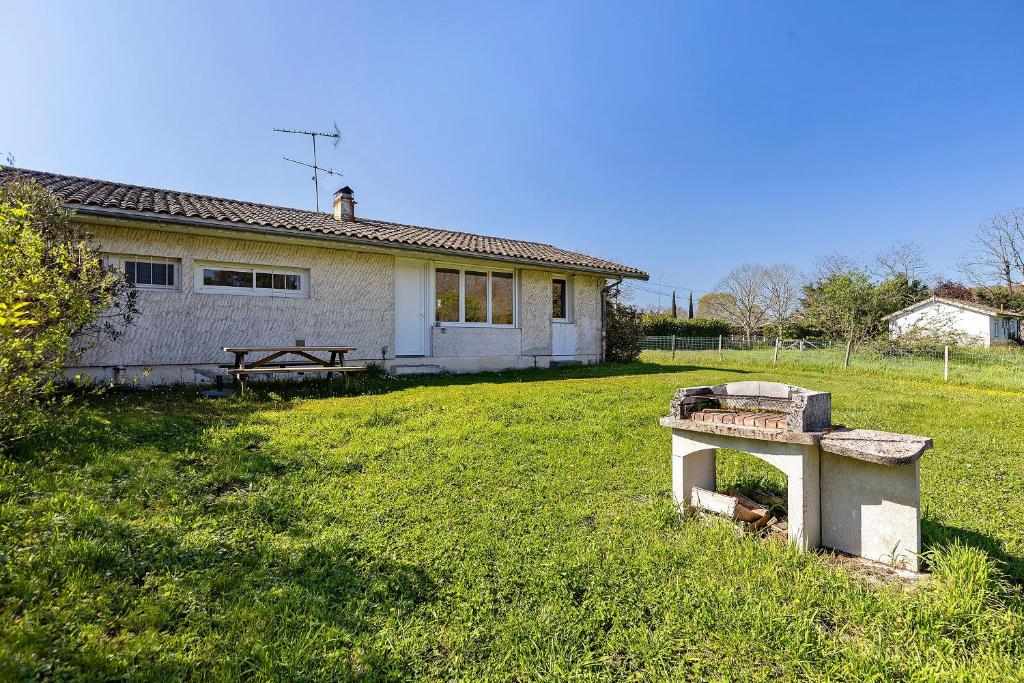 a house in a field next to a grass yard at Le Gîte du Château Saint Ahon in Blanquefort