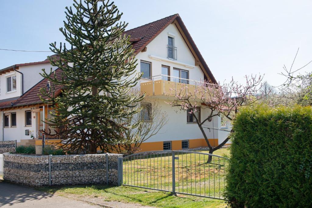 a house with a fence and a tree in front of it at Enderle in Uhldingen-Mühlhofen