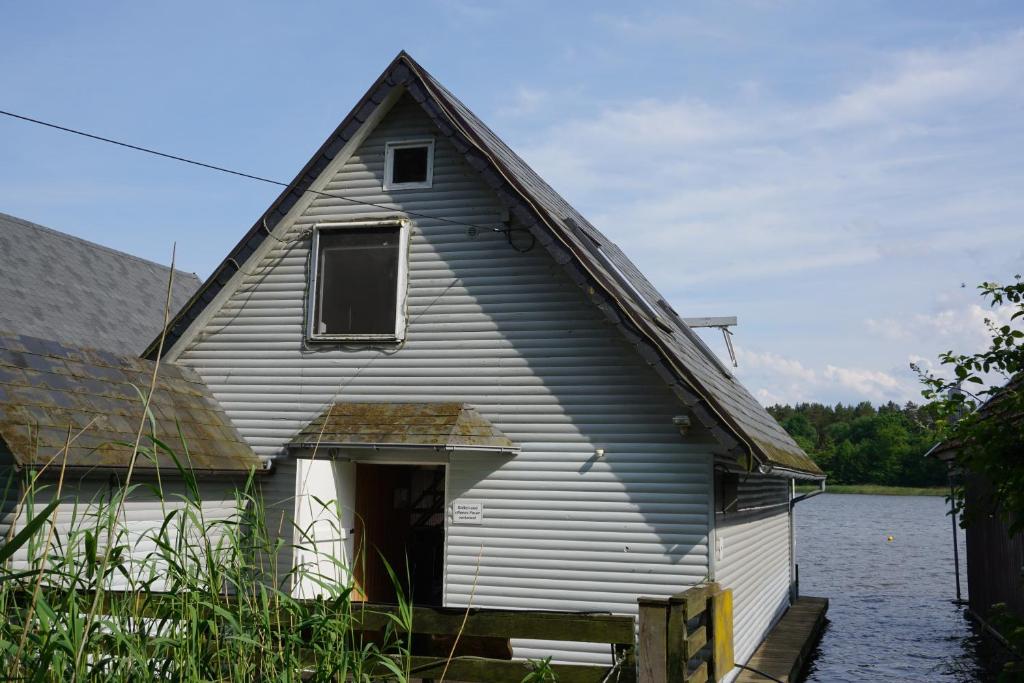 a house that is sitting in the water at Bootshaus Am Müritzarm in Vipperow